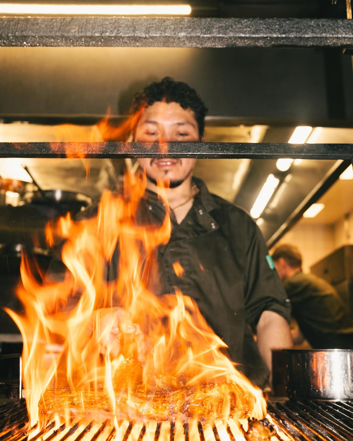 Naim cooking ribs over an open flame at Rollin Bistros