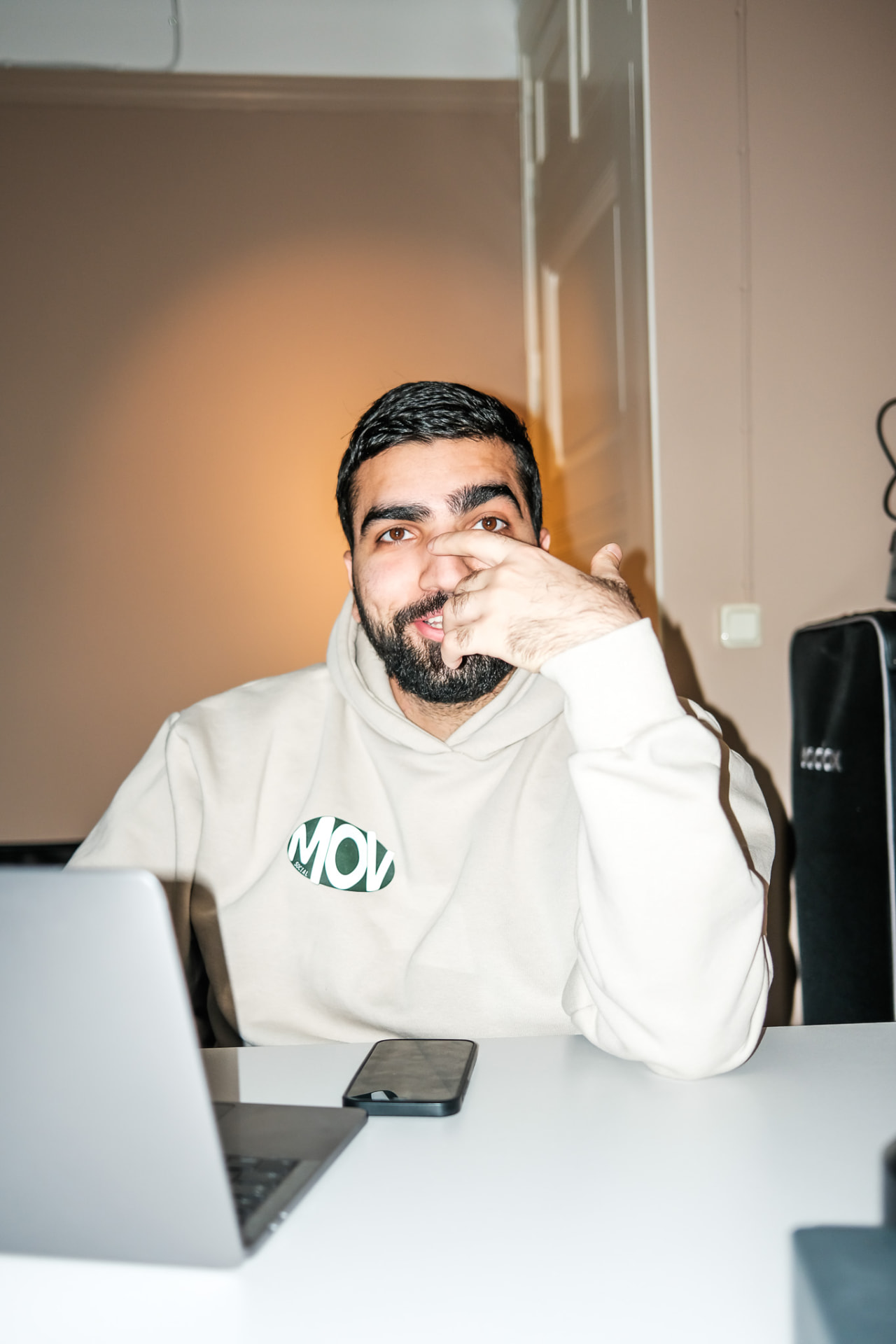 En i teamet vid ett skrivbord i studien med en Movsocial-hoodie.