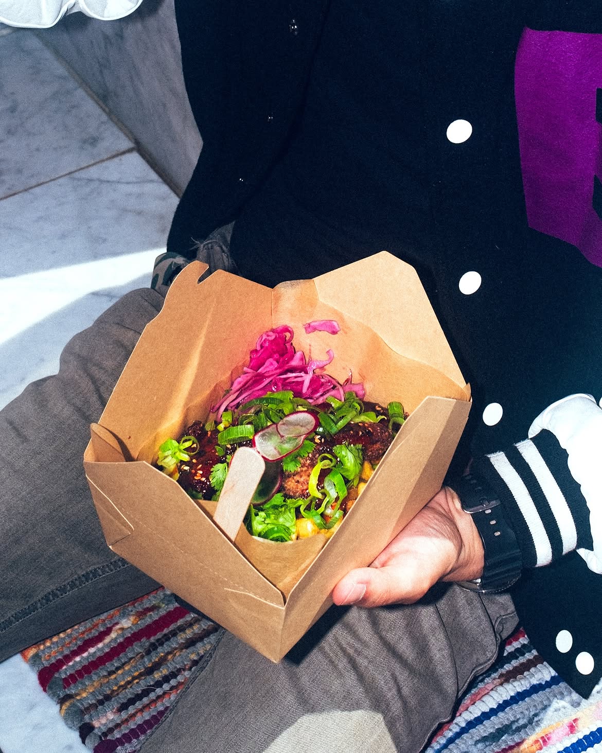 A guest holding a box of Korean fried chicken